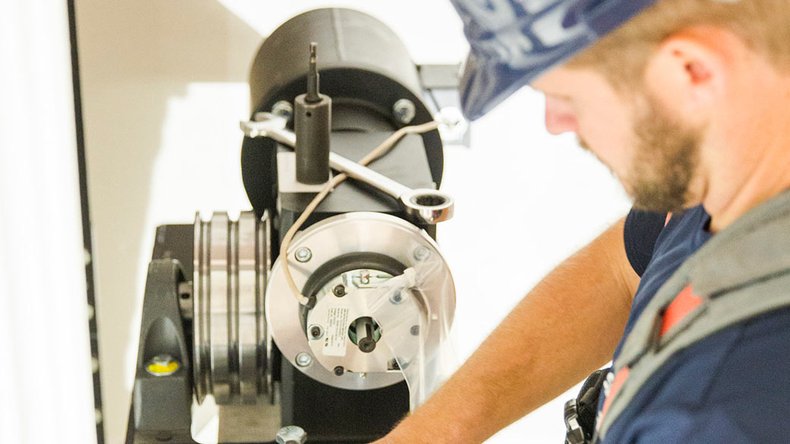 Technician working on mechanical elevator components.