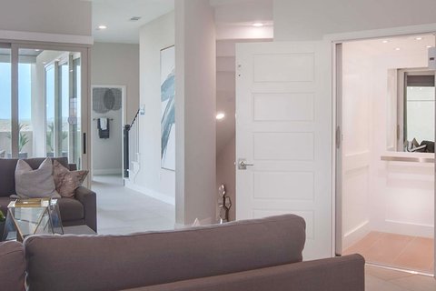 Open home elevator next to a modern living room