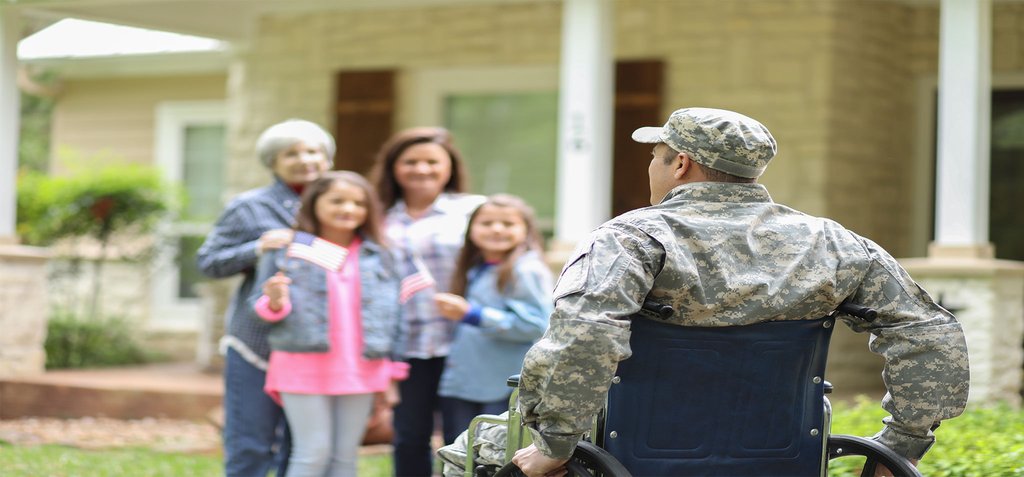 Soldier in a wheelchair facing his smiling family