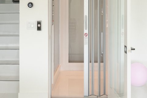 Home elevator beside a white staircase