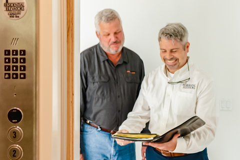 Going over the checklist for a residential elevator.