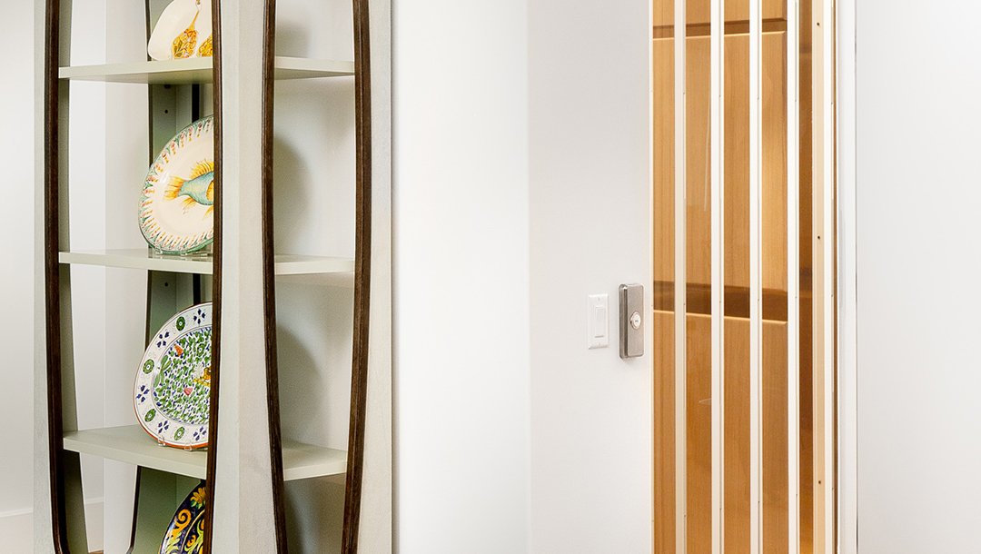 Home elevator opening in a hallway next to a display case