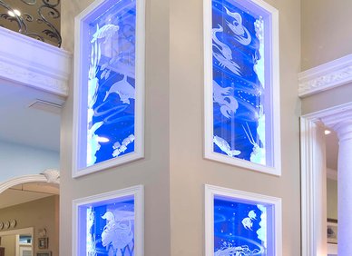 Tall home elevator shaft with ocean-themed glass panels
